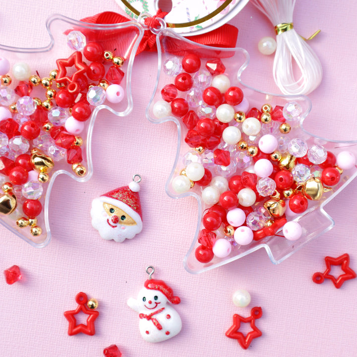 Decorative Christmas tree bead making set with red, white, and gold beads on a pink background.