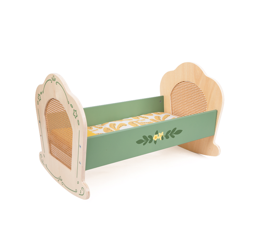 Wooden toy crib with green mattress and floral pattern on a white background