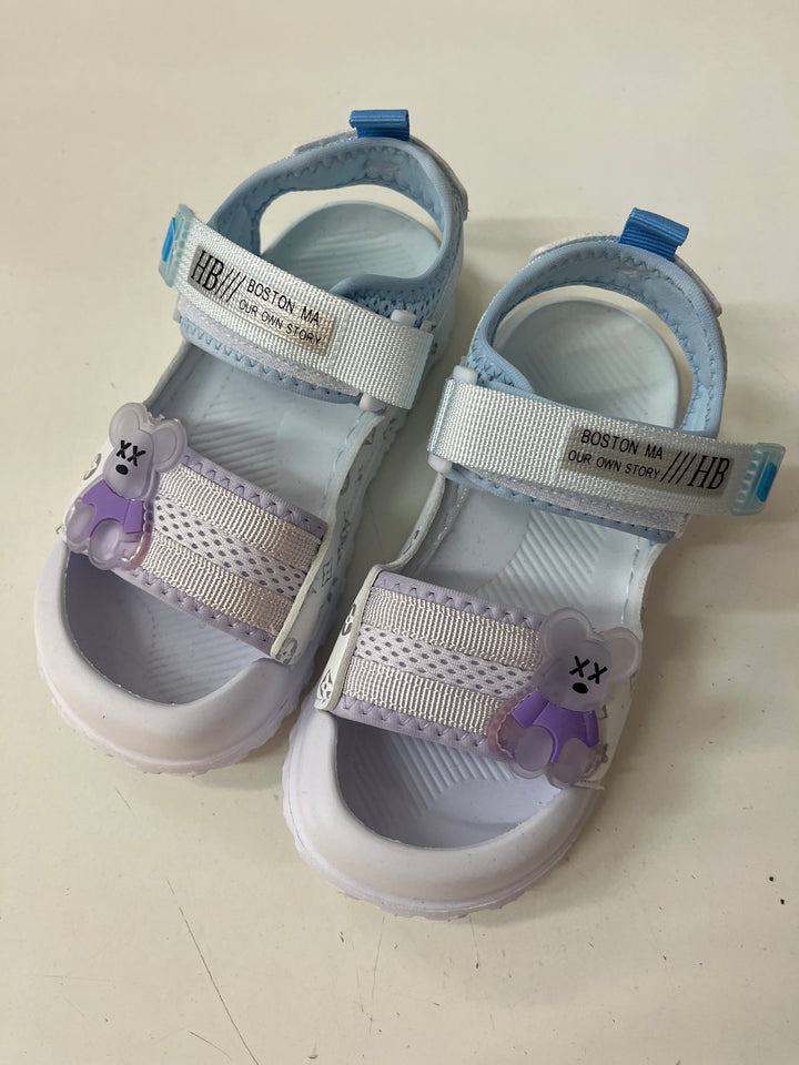 Pair of children's sandals with floral decorations on a light background