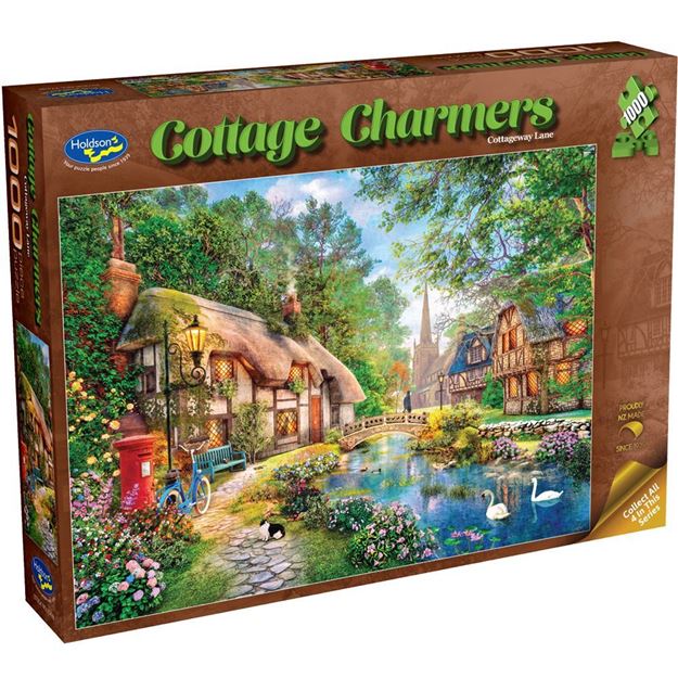 Box of Cottage Charmers puzzle featuring a scenic village with houses and a pond.