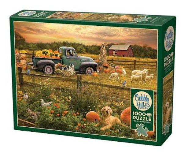 A boxed jigsaw puzzle on a plain white background. The front of the box shows a rustic autumn farm scene with a green pickup truck, sheep, ducks, pumpkins, flowers, and a golden retriever.