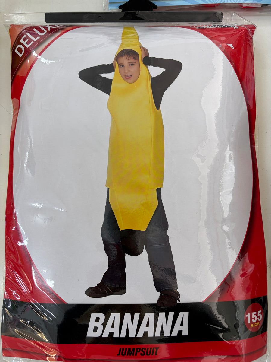 A child wearing a banana costume inside its retail packaging, featuring a bright yellow banana-shaped jumpsuit with a hood and a black long-sleeve shirt underneath. The packaging is red and white with the text 'DELUXE BANANA JUMPSUIT' and a size number '155'.