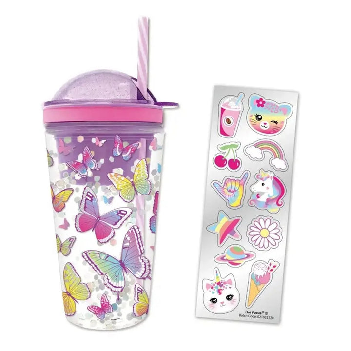 A clear plastic tumbler with a purple glittery lid and straw, decorated with colorful butterflies and pink glitter, shown next to a sheet of matching cartoon stickers on a white background.