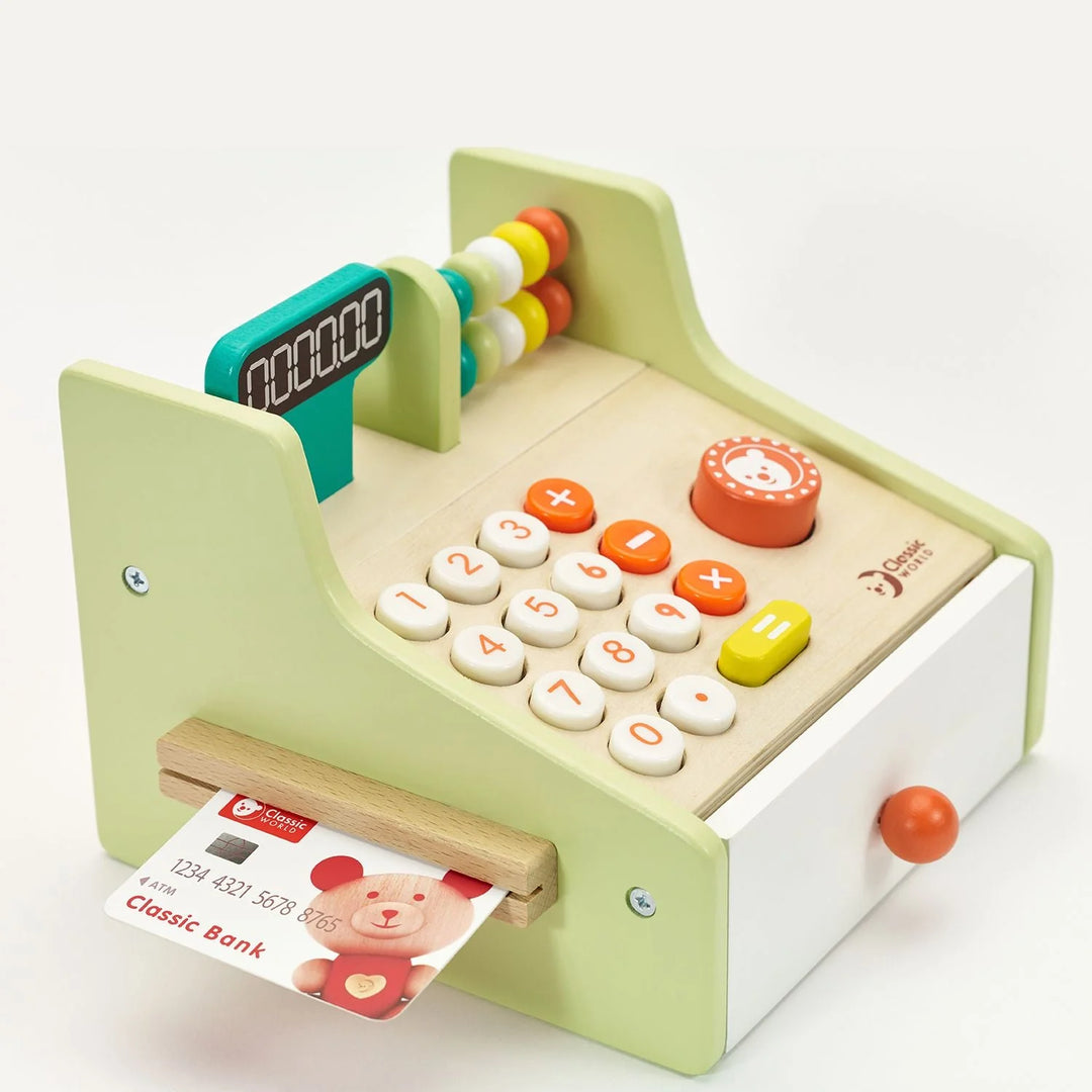 Toy cash register with colorful buttons and a bank card on a white background