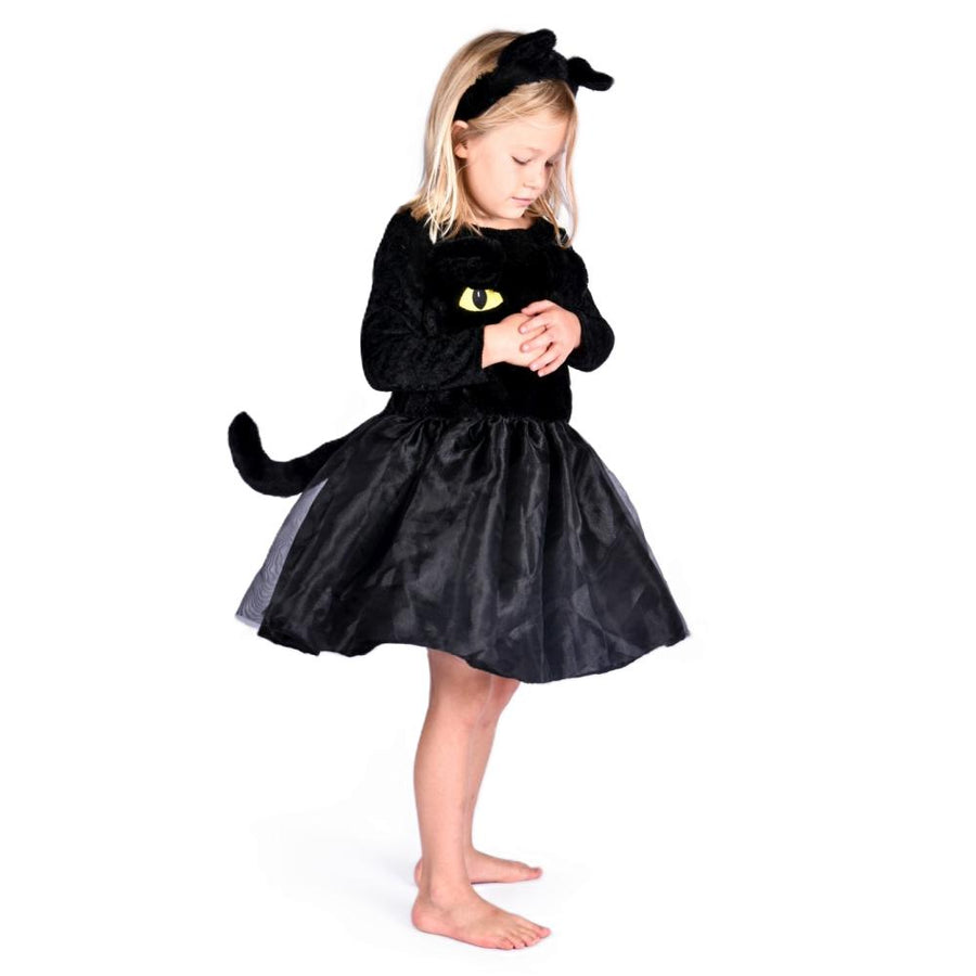 Child wearing a black cat costume with yellow eyes on a white background