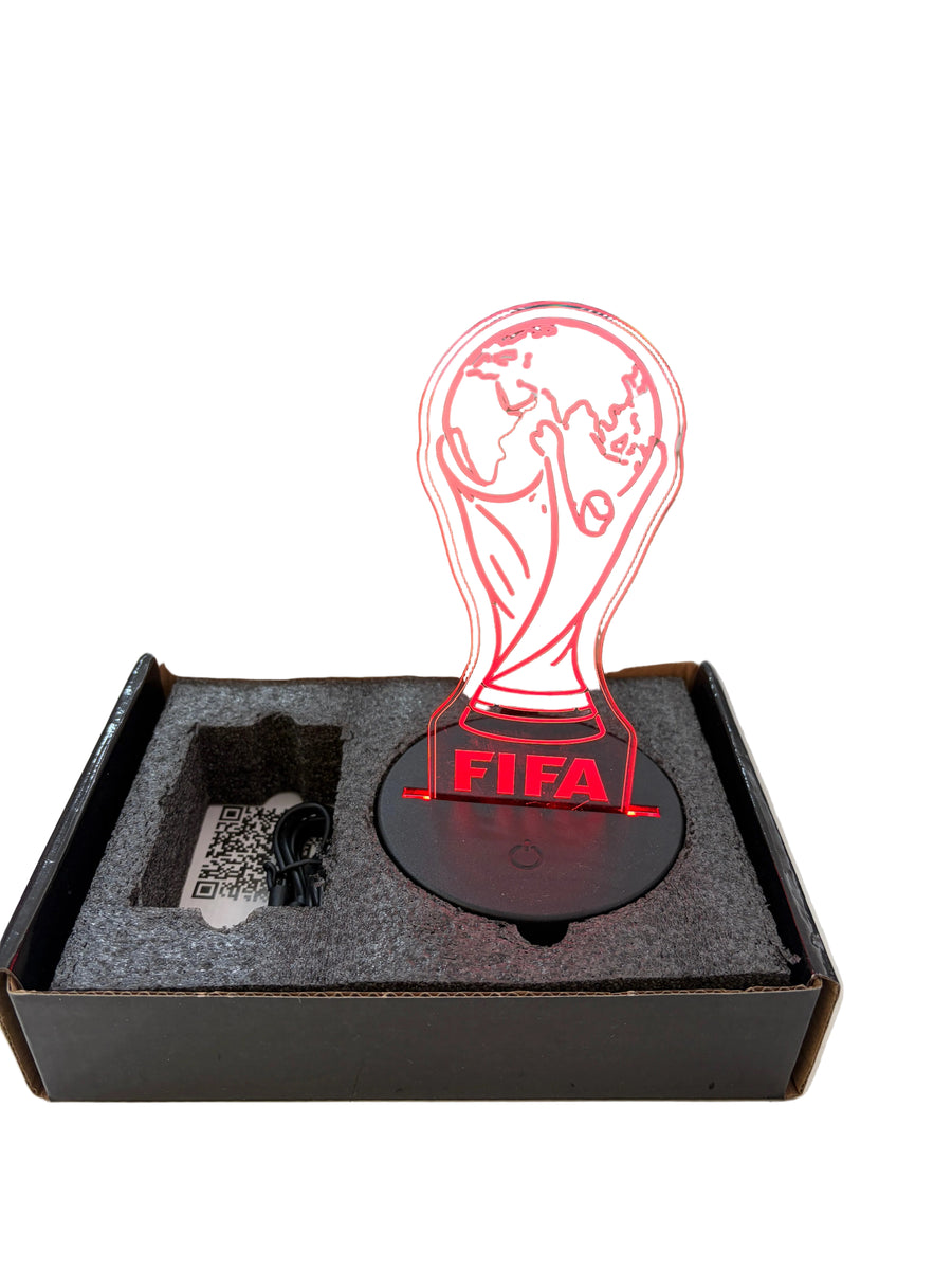 FIFA World Cup trophy LED night light in its original box, featuring a red illuminated trophy design with the FIFA logo on a black circular base.
