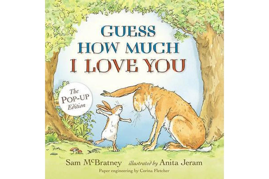 Front cover of the children's book 'Guess How Much I Love You' Pop-Up Edition, featuring a whimsical illustration of a rabbit and a hare under a tree with blue and brown lettering.