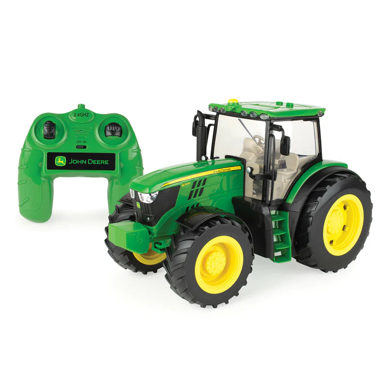 Green toy tractor with remote control on a white background john deere 