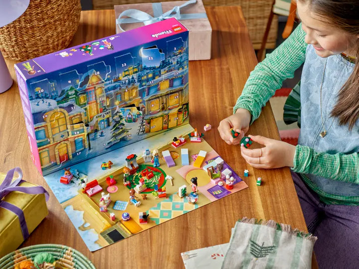 Child playing with a lego friends advent  set on a table next to an Amazon Advent calendar