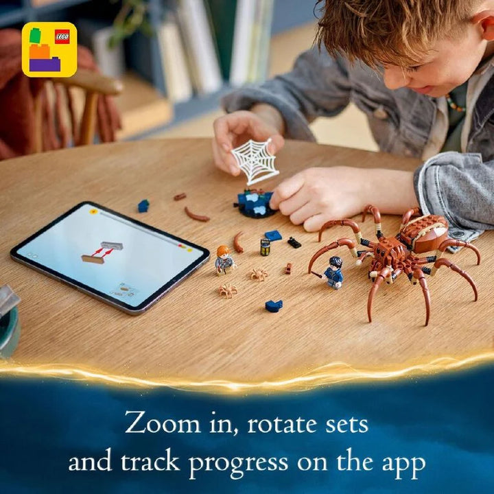 Child playing with LEGO Spider-Man set on a table with an iPad displaying the LEGO app.