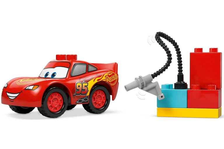 Red toy car with a character face and a set of building blocks on a white background