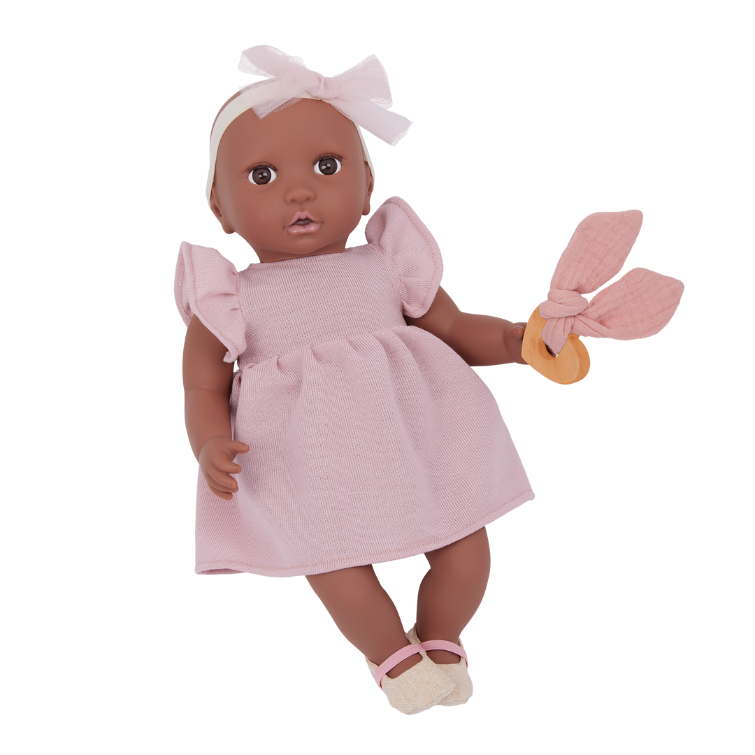 Doll in a pink dress with ruffled sleeves and a white headband on a white background
