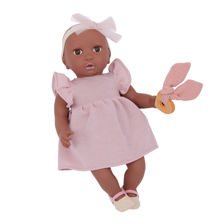 Doll in a pink dress with ruffled sleeves and a white headband on a white background