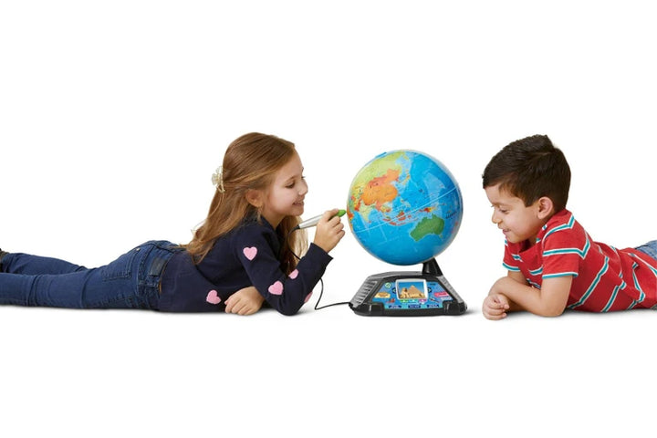 Two children lying on the floor looking at a Magic Adventures Globe Leap Frog