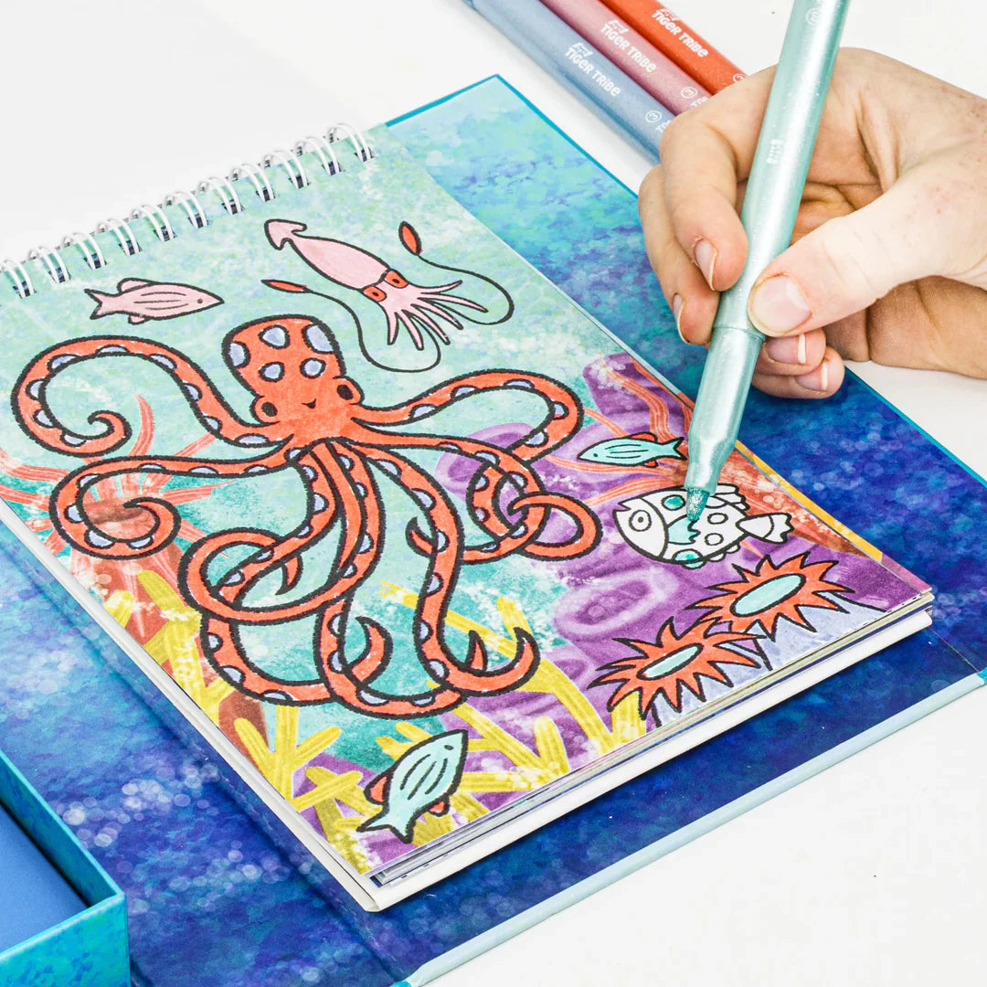 Coloring book with an octopus design, being colored by a hand with a pen.