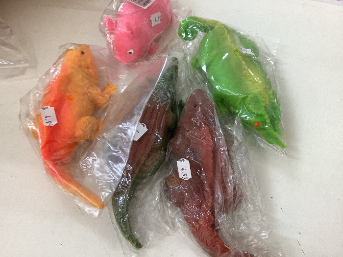 Assorted toy dinosaurs in clear plastic packaging on a white surface
