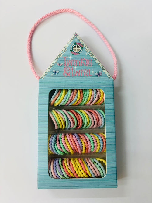 Pastel colored hair ties in a blue packaging with pink handle on a white background