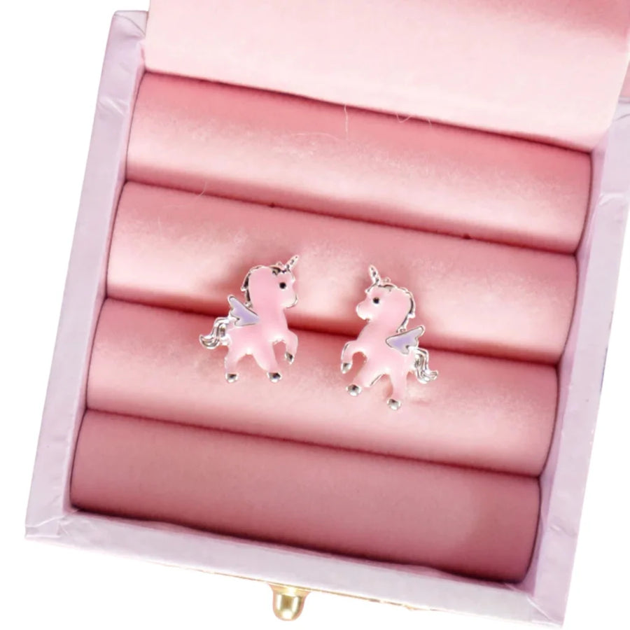 A pair of pink unicorn stud earrings with silver-toned metal outlines and wings, displayed on pink velvet ring rolls inside an open jewelry box.