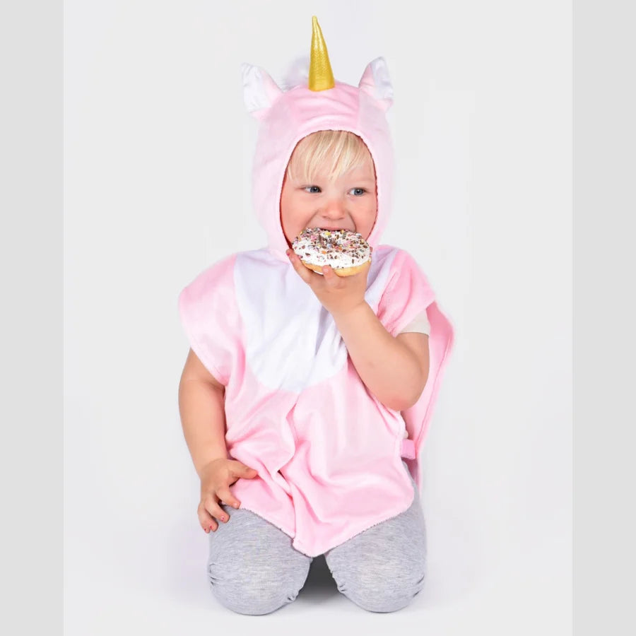 Child in a pink unicorn costume holding a donut against a white background