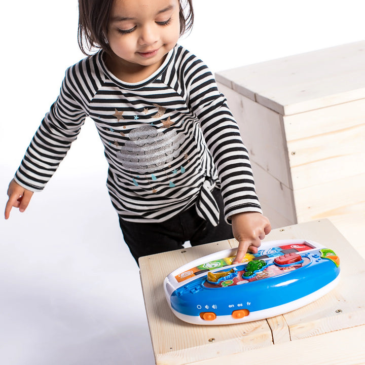 Child playing with a colorful toy on a light wooden floor.