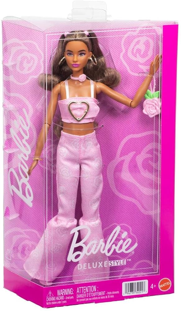 Barbie doll in pink outfit with heart details in a clear packaging box on a pink background