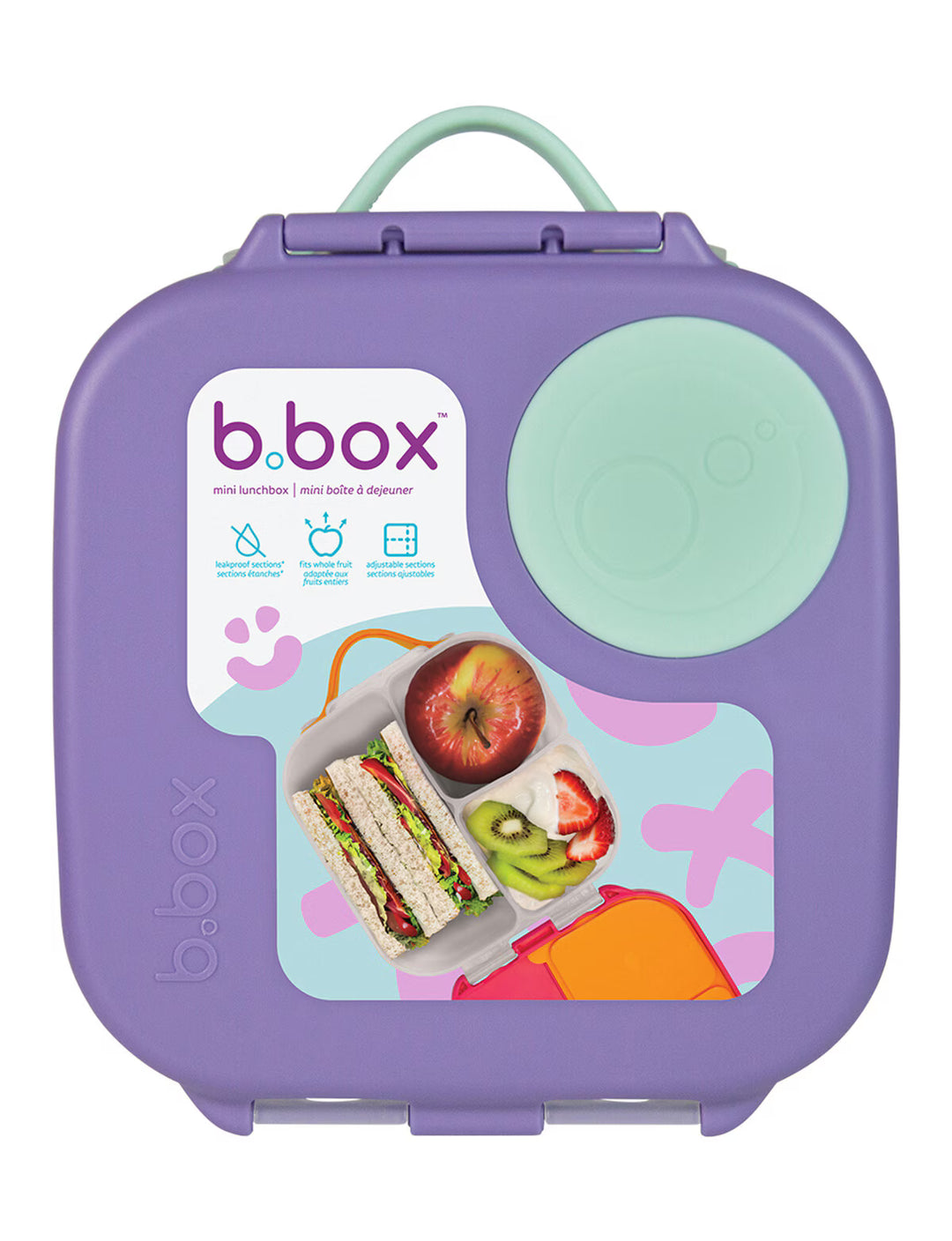A purple b.box lunch box with a mint green handle and a matching round lid insert, featuring a colorful front label with food illustrations and the b.