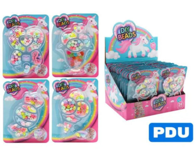 individually packaged DIY craft bead kits with unicorn and rainbow designs are shown alongside a matching retail display box. The packages feature colorful bead sets in clear plastic containers with pastel pink, blue, and multicolor bead mixes.