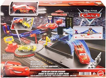 Disney Pixar Cars Piston Cup Starting Speedway toy set in its original retail packaging, featuring a blue and gray track with red and yellow race cars, a pit stop area, and various accessories.