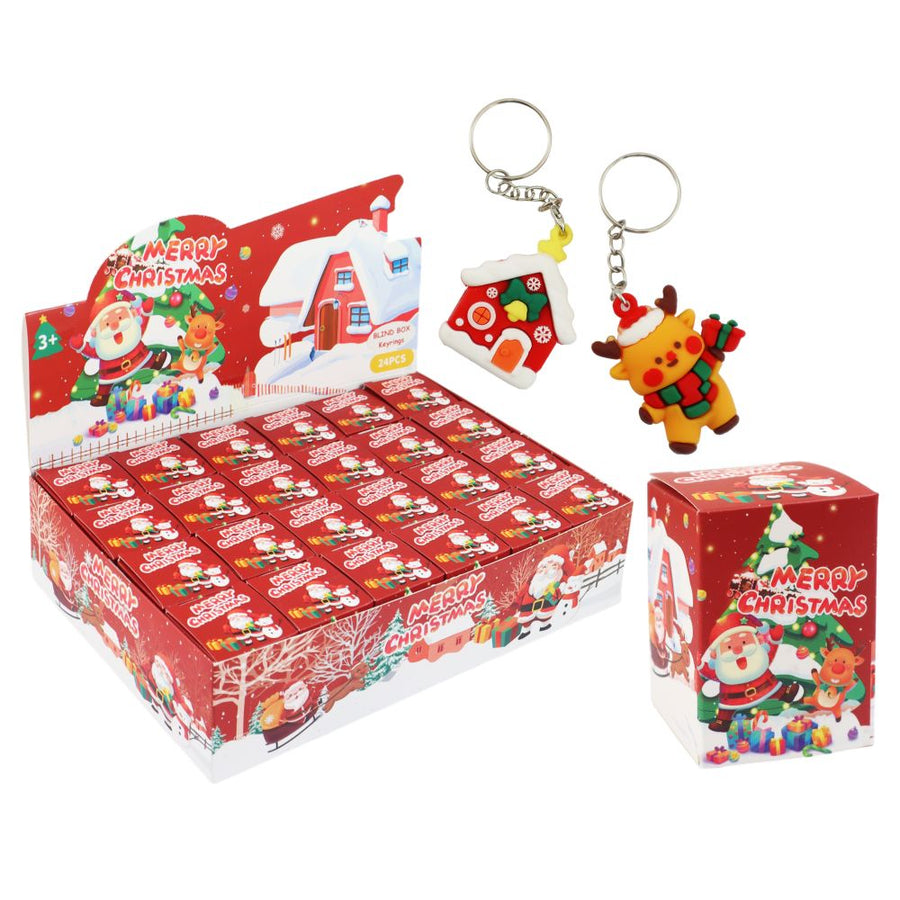 A retail display box and individual packaging for Christmas keychains, featuring Santa Claus and a house-shaped keychain on a plain white background.