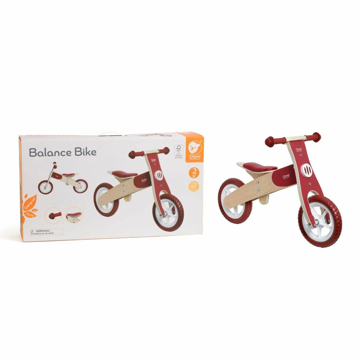 Wooden balance bike with red accents next to its packaging on a white background classic world brand