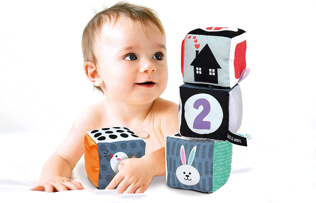 Baby playing with colorful blocks featuring numbers and animals on a white background
