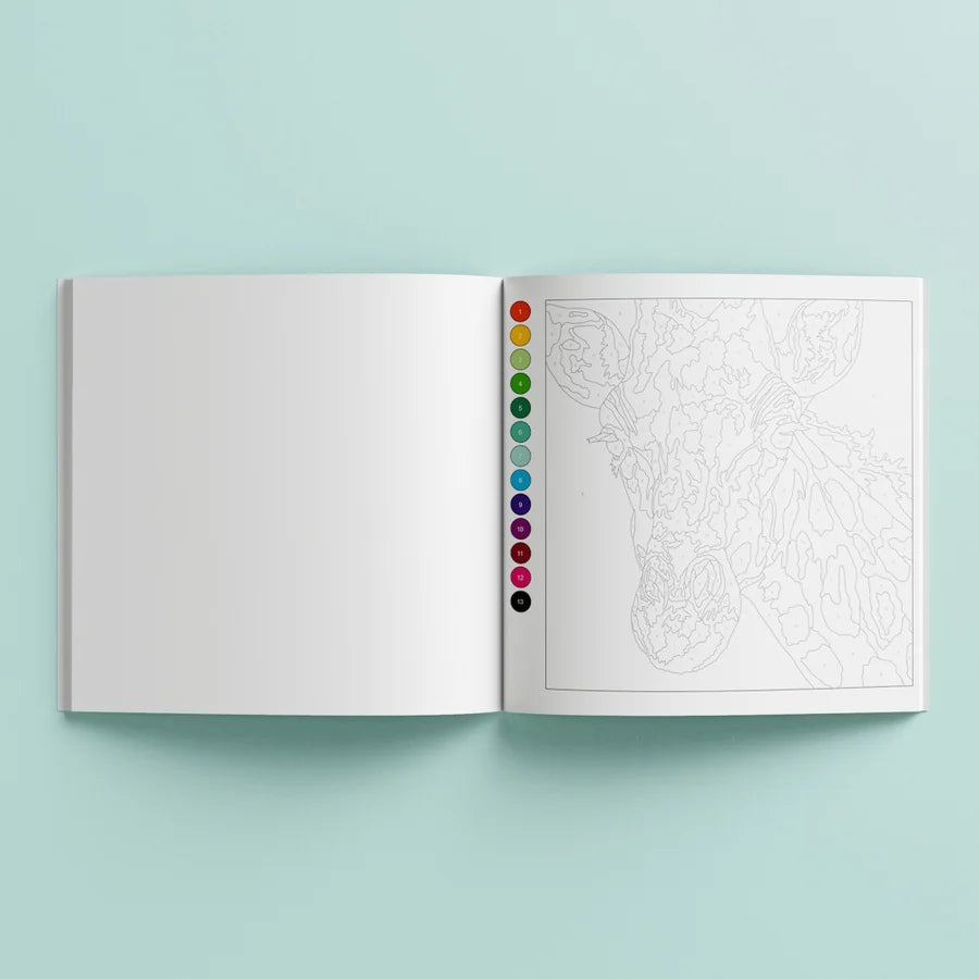An open coloring book or art booklet on a light mint background. The left page is blank white, and the right page shows a lightly sketched line drawing with a vertical row of colored circular swatches along the center edge.