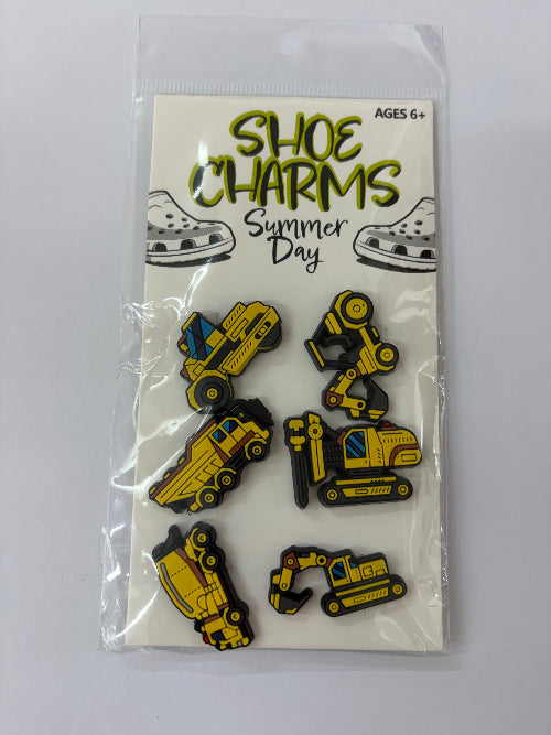 A package of 'Shoe Charms Summer Day' enamel pins by Shoe Charms, featuring six construction-themed pins (dump truck, excavator, bulldozer, and others) on a white backing card inside a clear plastic bag.