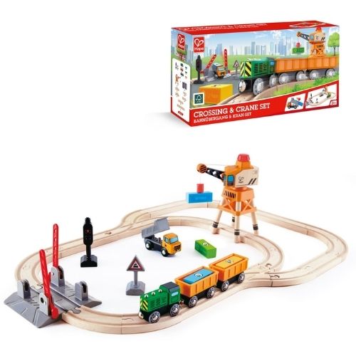 Toy train set with crossing and crane features on a white background