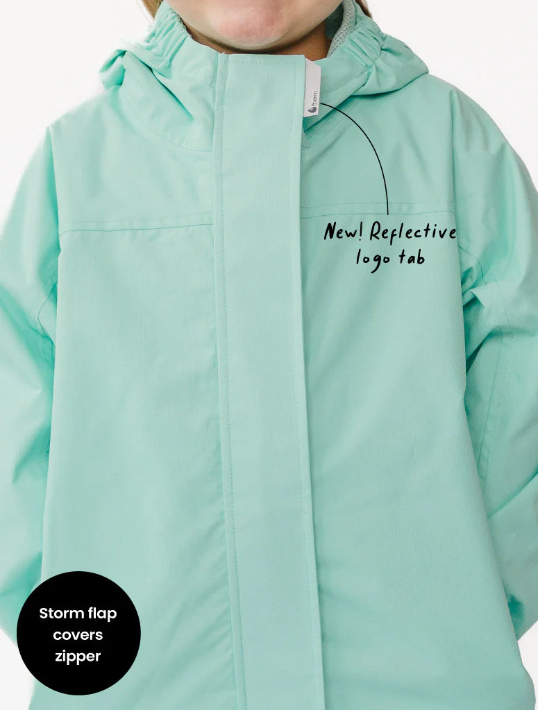 Light blue jacket with reflective logo tab and storm flap feature on a white background