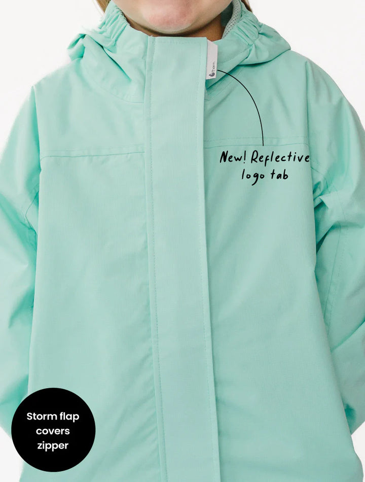 Light blue jacket with reflective logo tab and storm flap feature on a white background