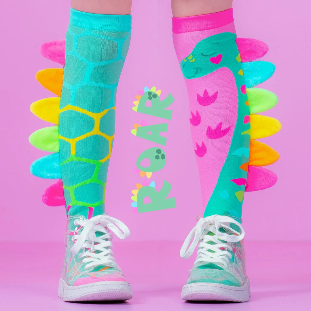 Colorful dinosaur-themed knee-high socks with 'ROAR' on a pink background