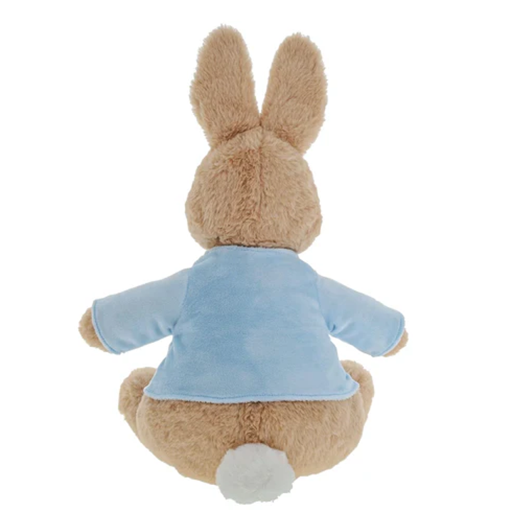 A plush stuffed rabbit toy shown from the back, with tan fur, long upright ears, a light blue shirt, and a white tail on a plain white background.