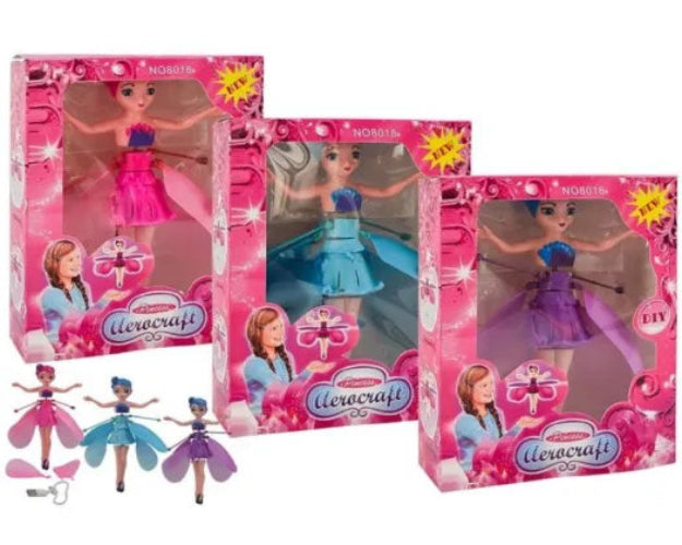 Three boxed fairy dolls in pink packaging, shown with the small unboxed dolls and wings placed in front on a white background.