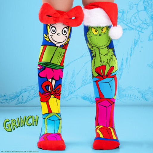 blue and red grinch socks with the grinch and cindy next to stacks of presents on a blue background