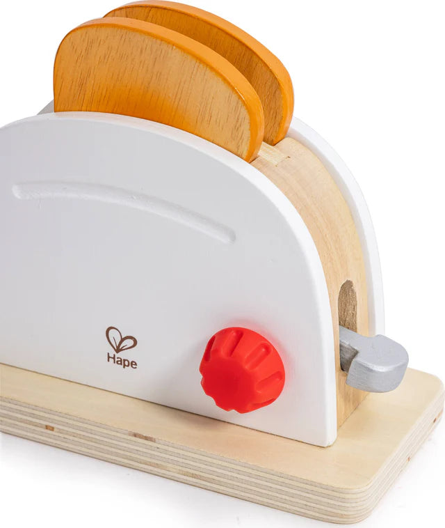 Wooden toy toaster with orange slices on a white background