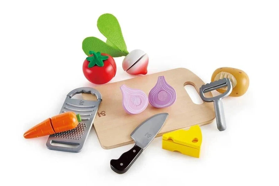 Set of toy kitchen utensils including a knife, cutting board, and vegetables on a white background