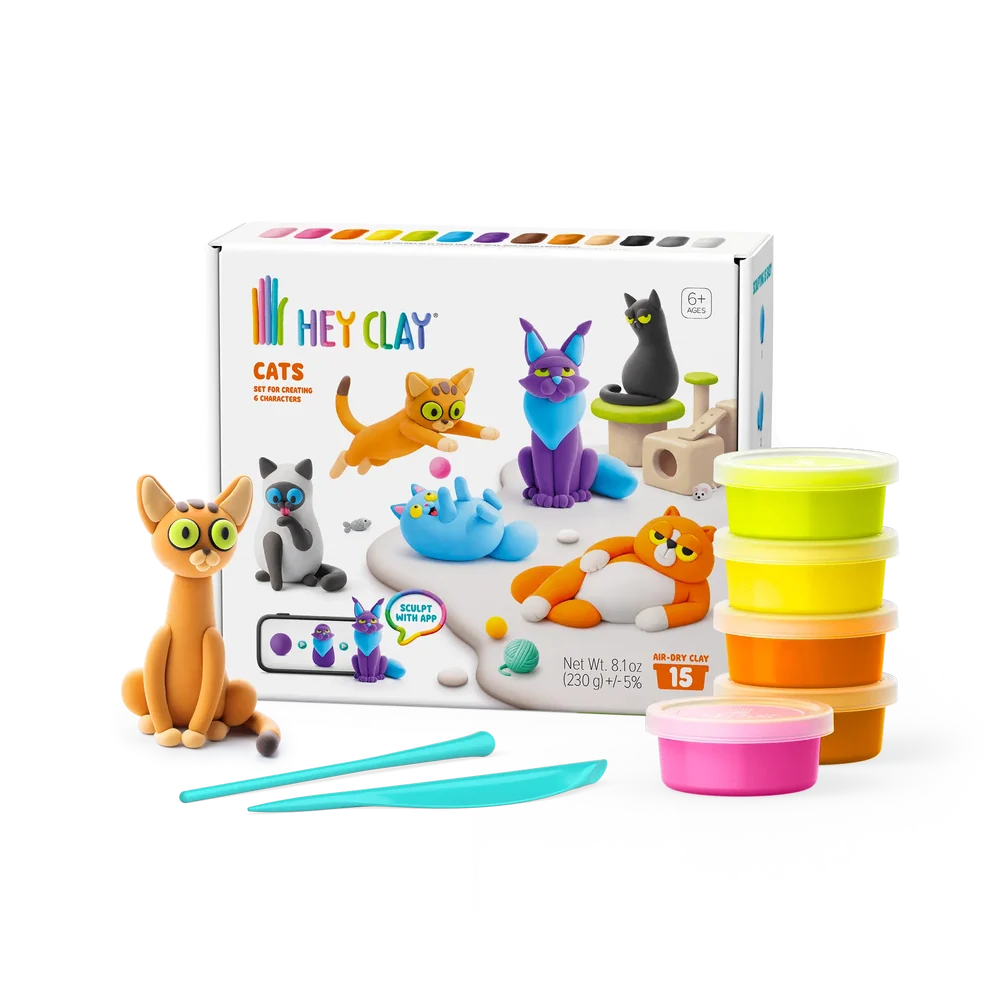 pottles of hey clay, sculpting tools, and a hey clay cat featured next to hey clat cats packaging