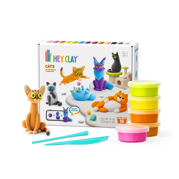 pottles of hey clay, sculpting tools, and a hey clay cat featured next to hey clat cats packaging