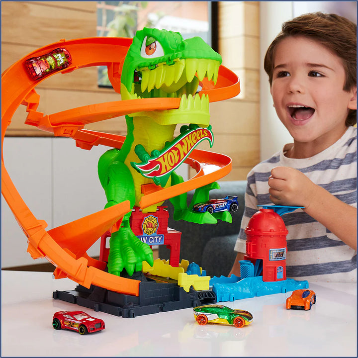Child playing with a Hot Wheels City T-Rex Blaze Battle Playset featuring a dinosaur-shaped track.