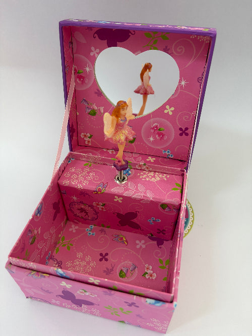 A pink and purple fairy-themed music box jewelry box with a heart-shaped window on the inside lid, featuring a dancing fairy figure and floral patterns.