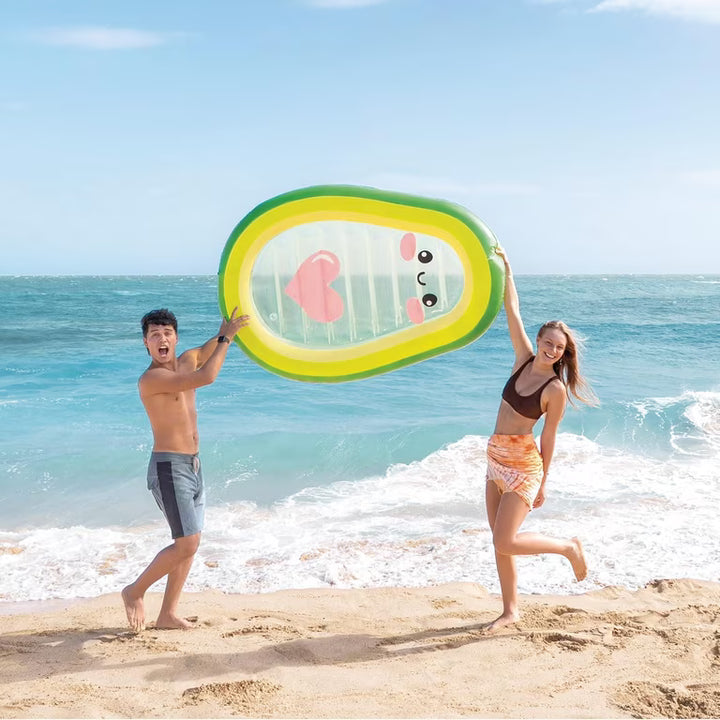 two people holding up the pool float on the beach
