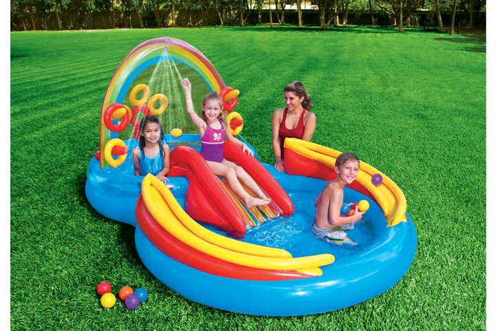 rainbow pool play centre in a green backyard with 3 kids and lady playing in the water