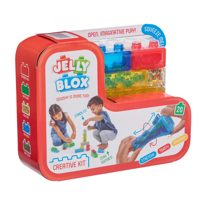Jelly Blox Creative Kit in a red metal tin box, featuring a transparent storage container filled with colorful building blocks and demonstration graphics of how to play on the front.