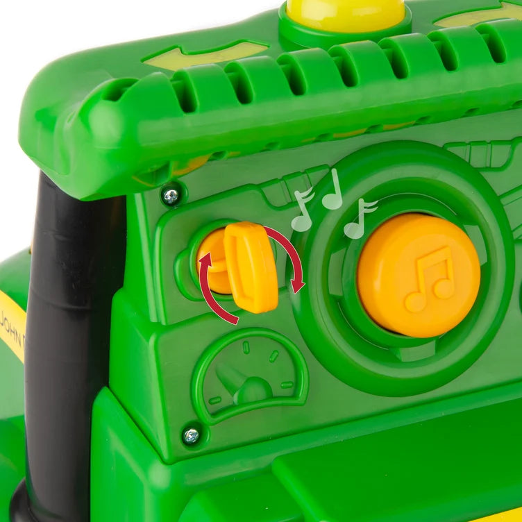 Close-up of a green toy tractor ride on with yellow buttons on a white background